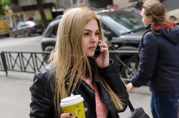 Mujer joven con café y teléfono — Foto de Stock