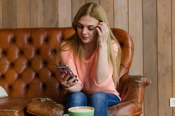 Mujer joven con café y teléfono — Foto de Stock