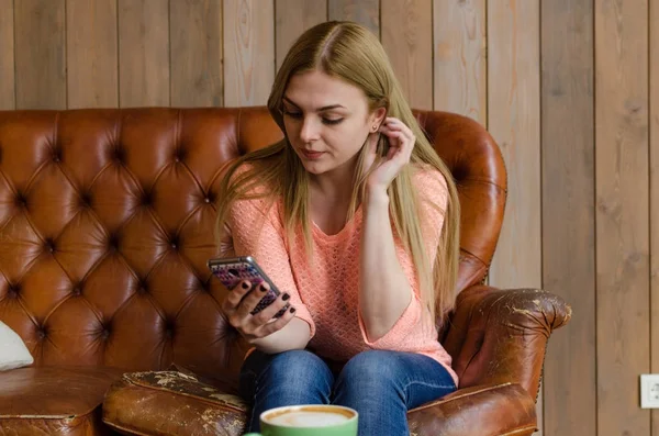 Mujer joven con café y teléfono — Foto de Stock