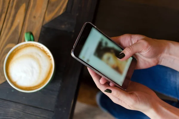 Mujer joven con café y teléfono — Foto de Stock