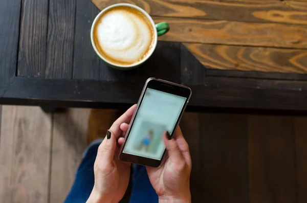 Mujer joven con café y teléfono — Foto de Stock