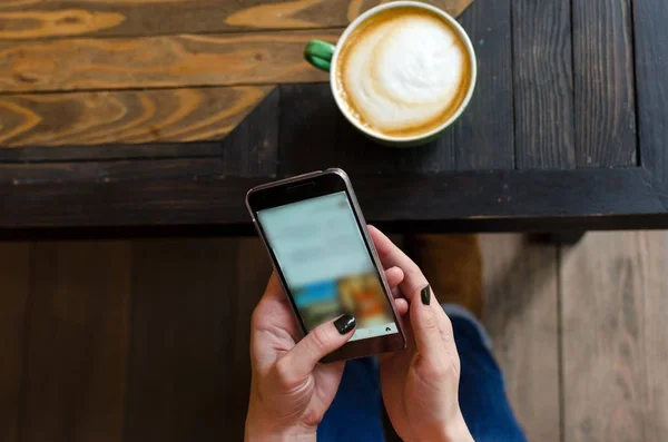 Mujer joven con café y teléfono — Foto de Stock