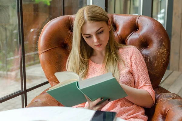 Jovencita está sentada con el libro —  Fotos de Stock