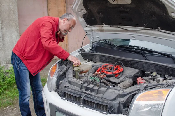 Aged man fixing the car Stock Photo