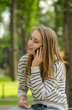 Genç bayan telefonunu kullanıyor.