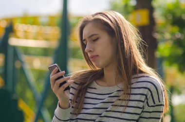 Genç bayan telefonunu kullanıyor.