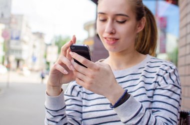 Genç bayan telefonunu kullanıyor.