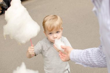 Küçük bebek oğlan pamuk şeker yiyor
