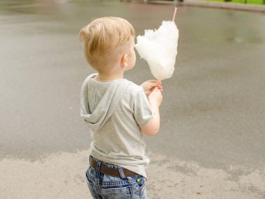 Küçük bebek çocuk parkta pamuk şeker yiyor