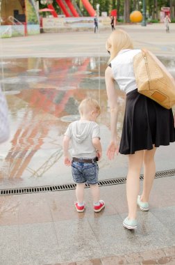 erkek bebek annesiyle birlikte parkta yürüyor