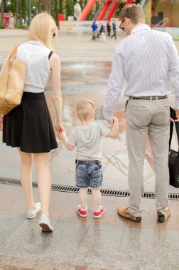Genç aile parkta yürüyor