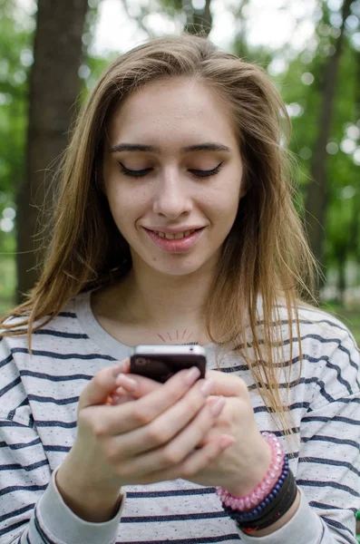 Молода жінка використовує свій телефон — стокове фото