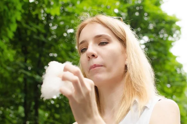 Woman is eating cotton candy in the park — Stock Photo, Image