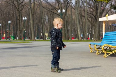 Parkta yürüyen küçük çocuk.