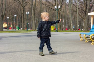Parkta yürüyen küçük çocuk.