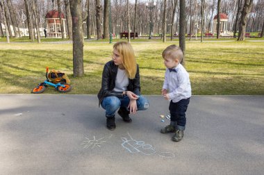Sarışın çocuk annesi ile resmi çiziyor