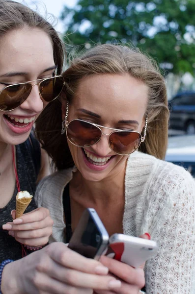 Two girlfriends are using cellphone — Stock Photo, Image