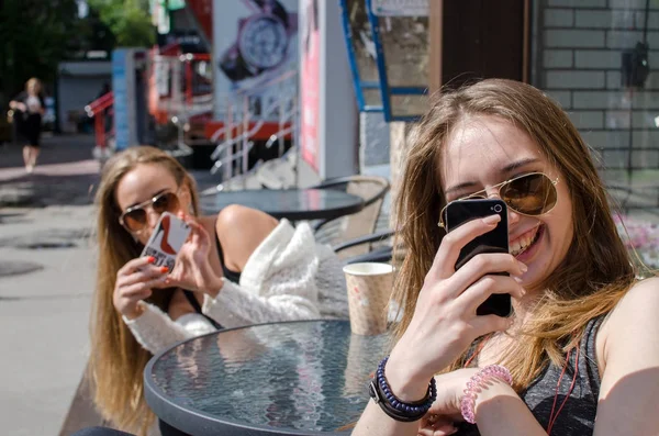 Two girlfriends are using cellphones — Stock Photo, Image