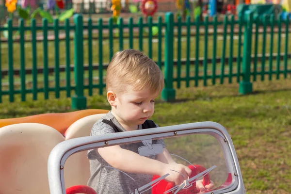 El niño está montando el coche. — Foto de Stock