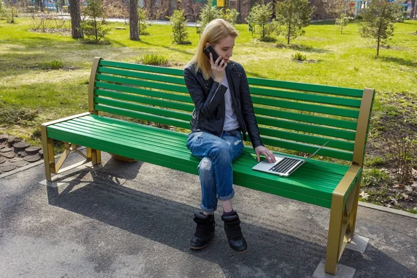 Mujer con portátil y teléfono — Foto de Stock