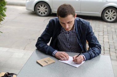 Genç adam not alıyor.