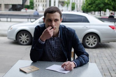 Genç adam not alıyor.