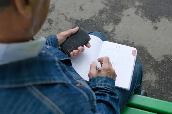 Hombre está tomando notas en el planificador diario — Foto de Stock