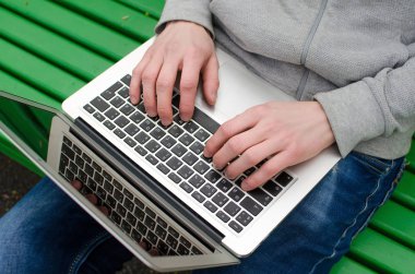 Genç adam laptopunu kullanıyor.