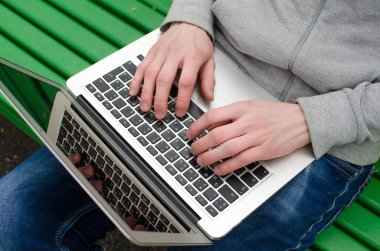 Genç adam laptopunu kullanıyor.