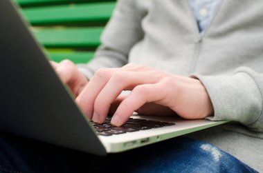 Genç adam laptopunu kullanıyor.