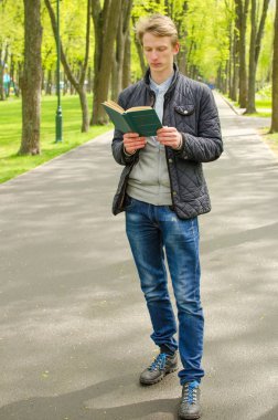 Genç adam kitap okuyor.