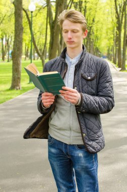 Genç adam kitap okuyor.