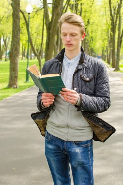 Genç adam kitap okuyor.