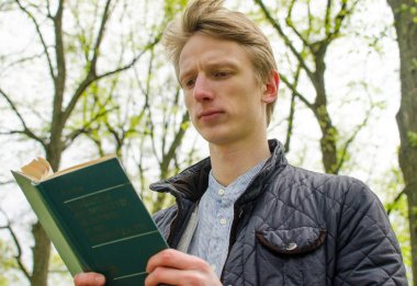 Genç adam kitap okuyor.