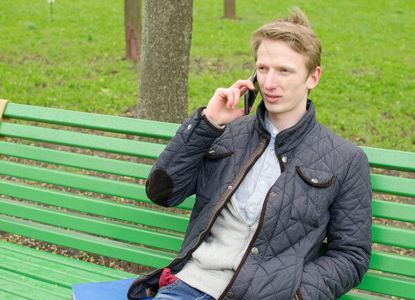 Молодой человек пользуется телефоном
