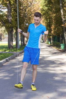 adam parkta ip atlama ile exersises yapma