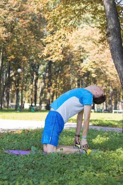 Az ember így xersises a parkban, a szőnyeget — Stock Fotó