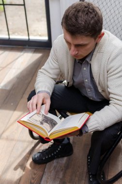 Kitap koltukta oturan adam