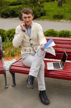 Genç adam telefonda konuşuyor.