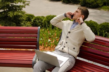 Genç adam telefonda konuşuyor.