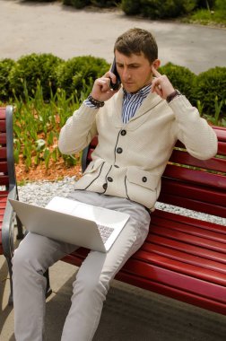 Genç adam telefonda konuşuyor.