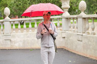 Genç adam şehirde yürüyor.