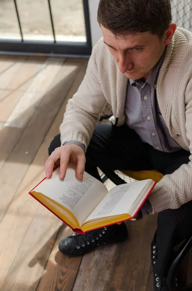 Hombre con libro sentado en el sillón —  Fotos de Stock