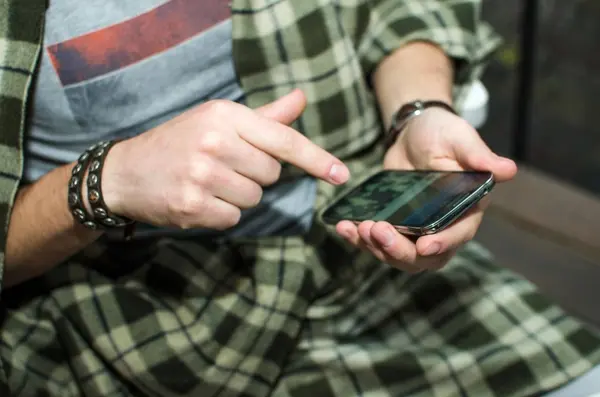 Молодой человек использует свой мобильный телефон — стоковое фото