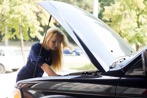 Frau repariert Auto unter der Motorhaube — Stockfoto