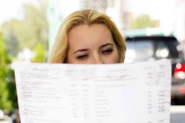 Blonde woman choosing from the menu — Stock Photo, Image