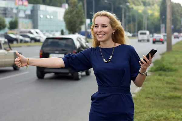 Kvinna med mobiltelefon är fånga taxi — Stockfoto