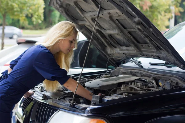 Woman reparing the car under the hood Stock Image