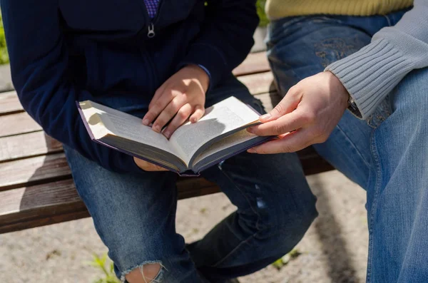 Joven está ayudando a adolescente a leer un libro —  Fotos de Stock