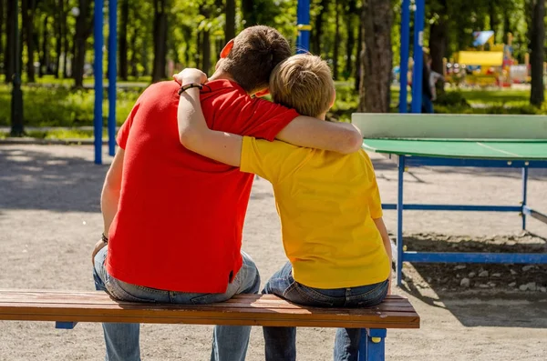 Joven hombre está sentado con adolescente — Foto de Stock